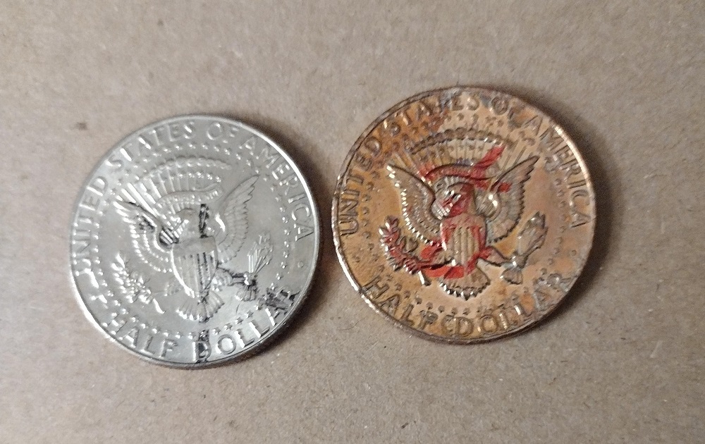 2023 Kennedy half dollar missing clad layer error showing copper-orange reverse contrasted with normal nickel obverse